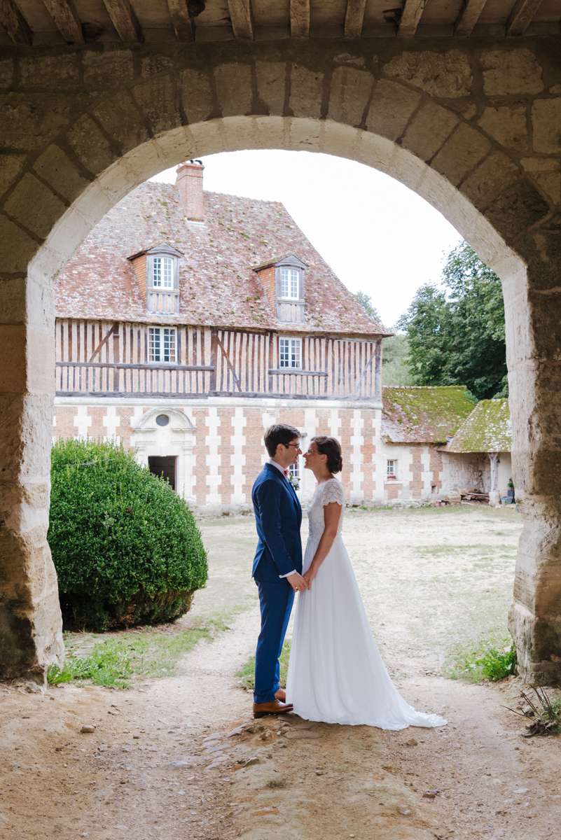 Bride and groom embracing under a stone archway at a Loire Valley chateau